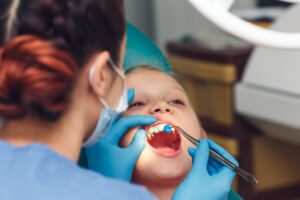 dentist applying fluoride to child's teeth